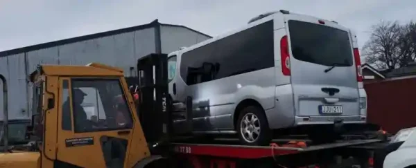 Äldre bil som står parkerad och väntar på upphämtning för bilskrotning efter stora tekniska problem.